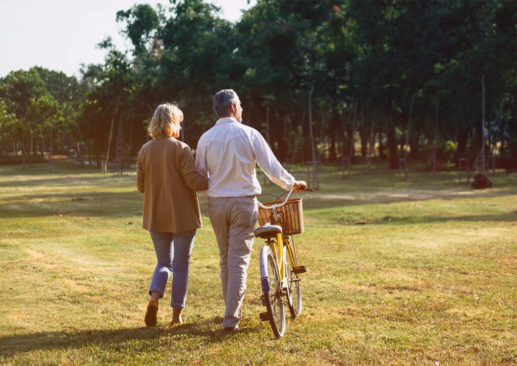 older couple walking and biking through grass what is an iul future financial solutions texas